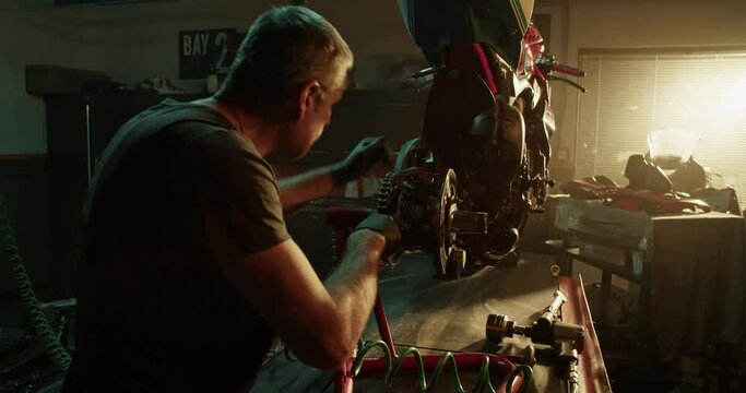 Professional mechanic tightening nuts in motorbike