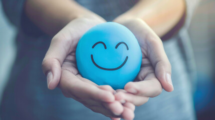 Naklejka premium Hands holding blue happy smile face. mental health positive thinking and growth mindset, mental health care recovery to happiness emotion