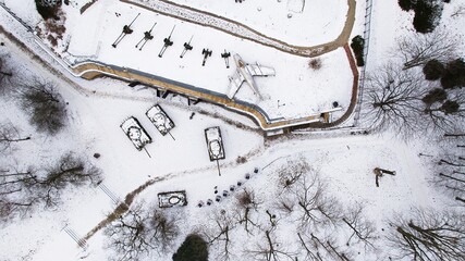 Snow-covered tanks, artillery, and a jet fighter in Poznań Citadel during winter, captured by...