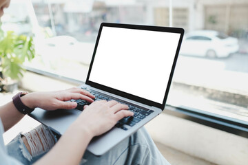 A white blank screen for hand typing text,using laptop contact business searching information in workplace on desk at cafe.