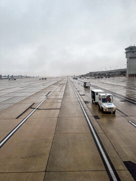 Dulles International Airport, Washington DC, USA - United Airlines Baggage tractor on the Taxi way on a rainy day 