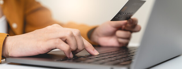 Hands of person entering credit card data laptop computer during pay for internet shopping online...
