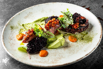 Cooked octopus and black rice in plate