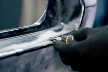 close-up at a service station grinding a rubber gasket on a metal part of the machine with a...
