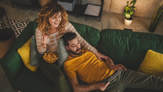 Couple caucasian man and woman at home on sofa bed watch movie