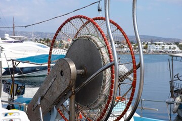 A close-up shot of a fishing boat net winch on a boat which is standing at a port.