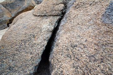 A large crack on a cobblestone in the desert. The texture and natural composition of the stones are clearly visible