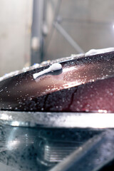 at a service station in a car wash a soaked part of a soapy burgundy car