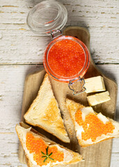 sandwiches with butter and red caviar. on a wooden background. food