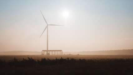 Windturbine in a field in a foggy summer morning, Latvia