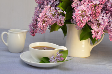 romantic image of a bouquet of lilacs and a cup of coffee