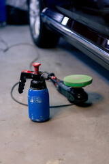 close-up of metal part for grinding at a service station and a blue spray bottle standing next to it