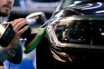 close-up of the hands of a car mechanic at a service station doing the final polishing to shine