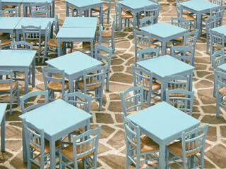 Empty tables and chairs of a taverna - obrazy, fototapety, plakaty