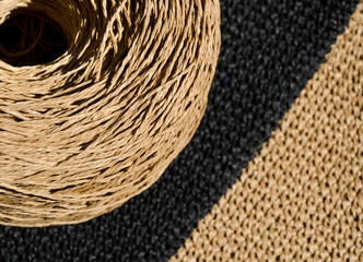 Close-up of a skein of ECO raffia against a background of black and beige napkins. Crochet.