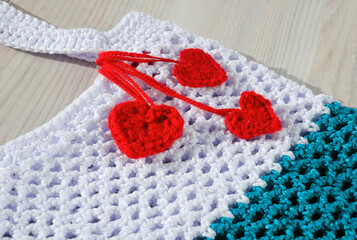 Women's bag made of polyester cord is decorated with red hearts.