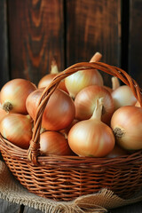Fresh raw  onions in wicker basket on wooden background