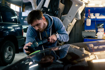 the car mechanic at a service station doing the final polishing to shine