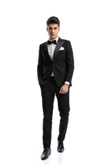 full length picture of elegant fashion man in black tux walking