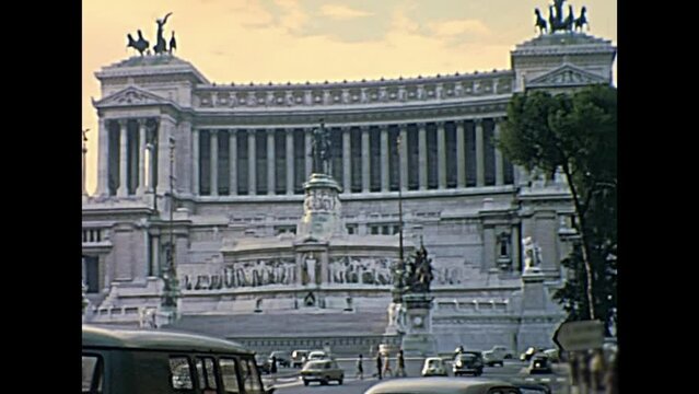 ROME, ITALY - CIRCA 1967: Vittoriano or Altare della Patria, patriotic monument. In Venice square with people and classic 1960s Fiat cars in Rome beside Campidoglio hill. Historic restored footage.