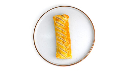 Overhead top down view of sausage roll Isolated on a plate. baked pastry with white background, no people and copy space. Golden yellow and brown pastry.