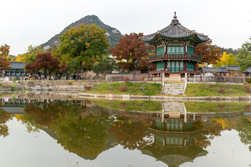 Seoul city,  South Korea - 26 October 2022 :Sunset Hyangwonjeong Pavilion in Gyeongbokgung Palace with Autumn season and cityscape background, Seoul city,  South Korea