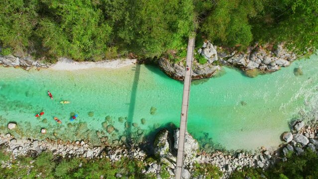 A suspension bridge spans the emerald waters of the Soca River in Slovenia