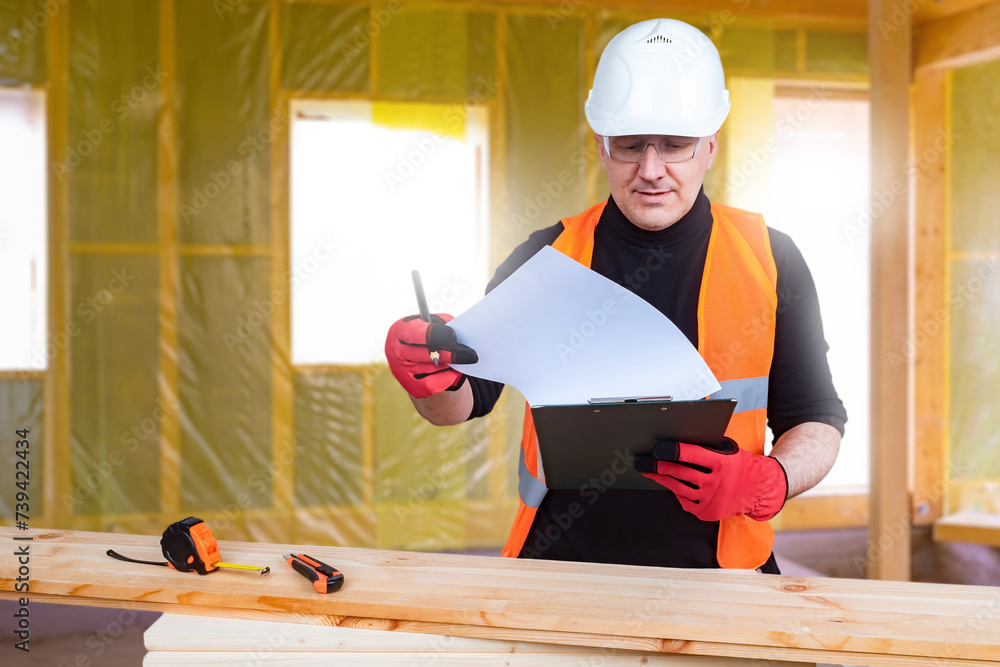 Poster man builder works with wood. guy is carpenter processing wood. builder with clipboard inside house u