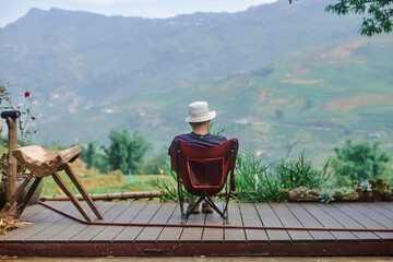 man sitting resting beautiful views of the mountains in sapa, vietnam - 739422626