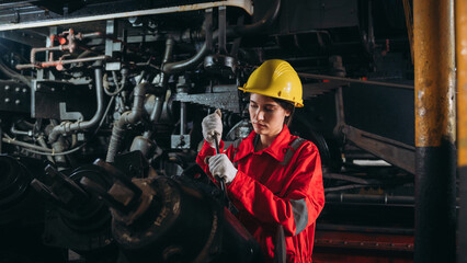 Industrial engineers inspect and perform maintenance on the machines at factory machines. Teamwork...