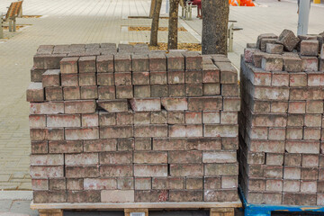 Close-up view of sidewalk tiles arranged on pallets outdoors. Curacao.