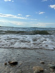 Sand beach and blue sea. Close up soft wave lapped the sandy beach. Beautiful sea waves with foam of blue and turquoise color isolated. Powerful ocean blue waves.