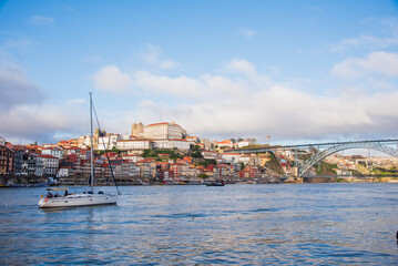 Fototapeta na wymiar A yacht on the Douro River in Porto, in front of the Luís I Bridge