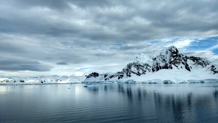 Fototapeta premium Mountains on Antarctica and icebergs floating on the water.