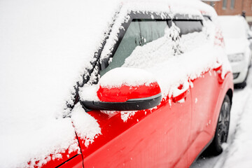 A red car covered with snow in winter. Samara, Russia - 7 Jan 2024