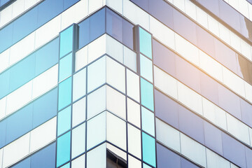 Architectural detail. Geometric abstract background of windows and reflections at sunset. Cool tones with warm sunlight