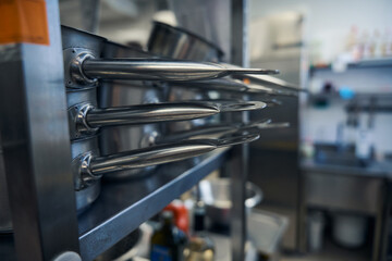 Shiny, polished frying pans on kitchen racks