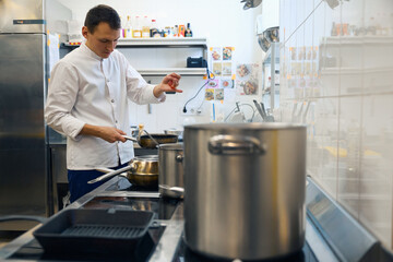 Guy in a uniform prepares food in a restaurant kitchen