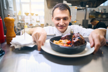 Cook has prepared lamb shank with vegetables for serving
