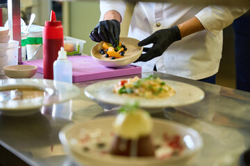 Chef decorates ready-made dishes for serving