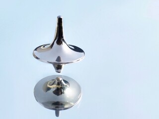 Reflection in a mirror of a inception peg top spinning 