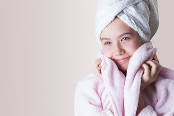Beautiful young woman smiling, wrapped in her bathrobe and a towel on her head
