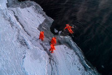 Tourists enjoy floating in dry survival suit in the middle of Arctic Sea.