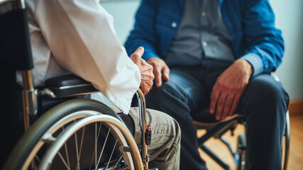 Obraz premium The doctor and patient are both in wheelchairs, discussing medical treatment. Comforting, empathy. Disability concept.