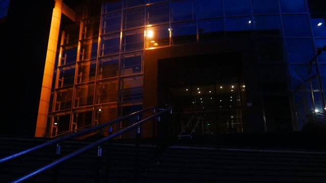 Reflexion lumière sur mur vitré, architecture moderne et écologique, soirée, éclairage de lumière urbaine orange, environnement urbain, style futuriste, grand et haut bâtiment, la nuit ou soirée, vide
