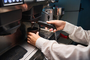 Barista prepares coffee in a coffee machine