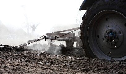 A tractor plows a field - prepares the land for sowing. Macro plows, agriculture concept