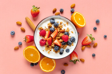 Healthy breakfast bowl with ingredients granola fruits Greek yogurt and berries on a pink background top view. Weight loss, healthy lifestyle and eating concept - Powered by Adobe