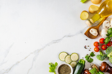 Healthy food cooking ingredients background with fresh vegetables, herbs, spices and olive oil on...
