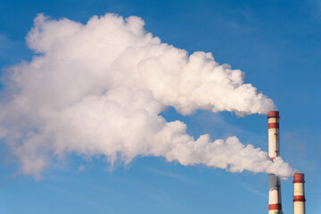 White Smoke from Industrial Chimneys against Clear Blue Sky — Environmental Pollution Concept with Air Emissions